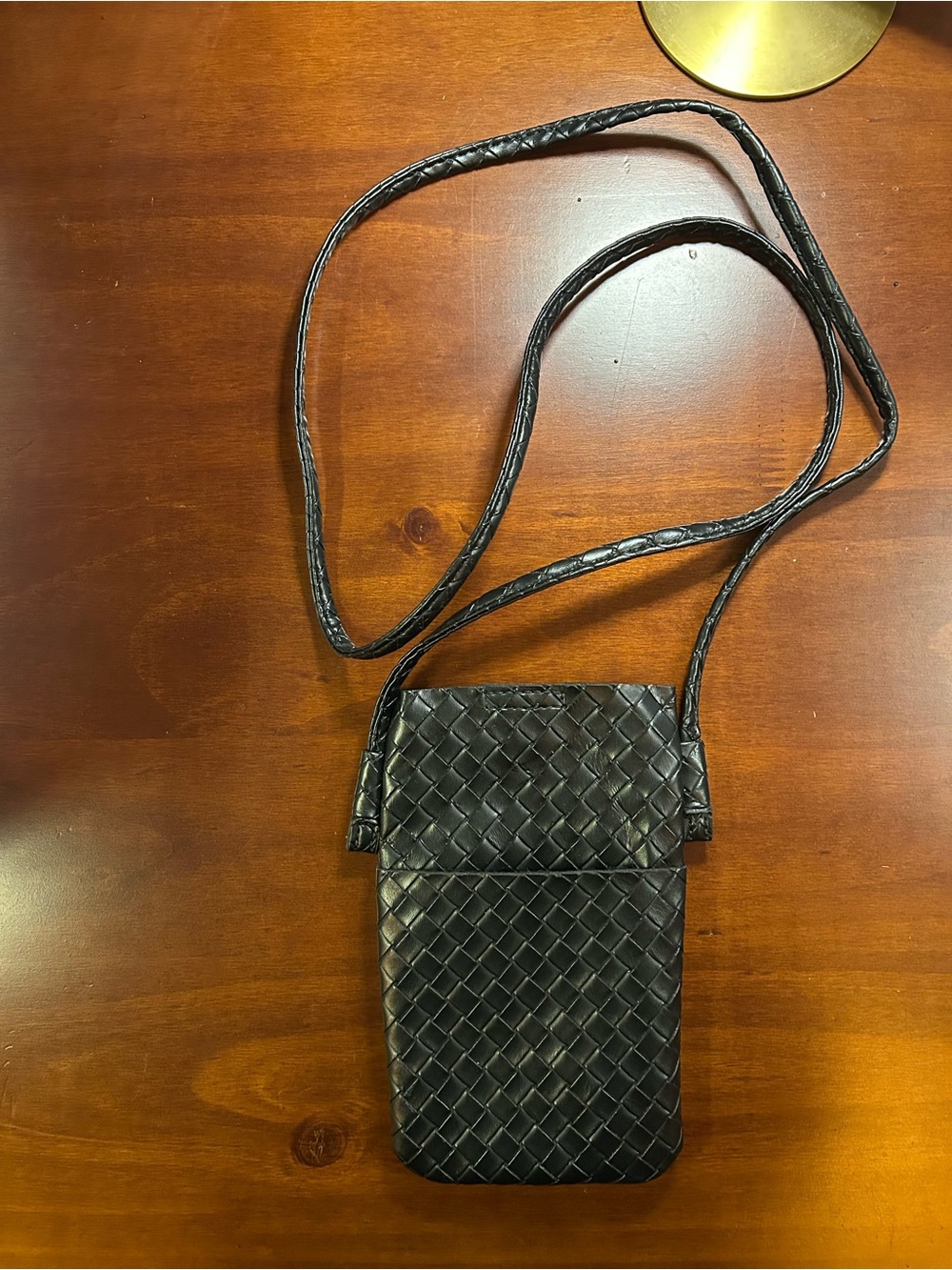 Black woven faux leather crossbody bag with a chic, textured finish